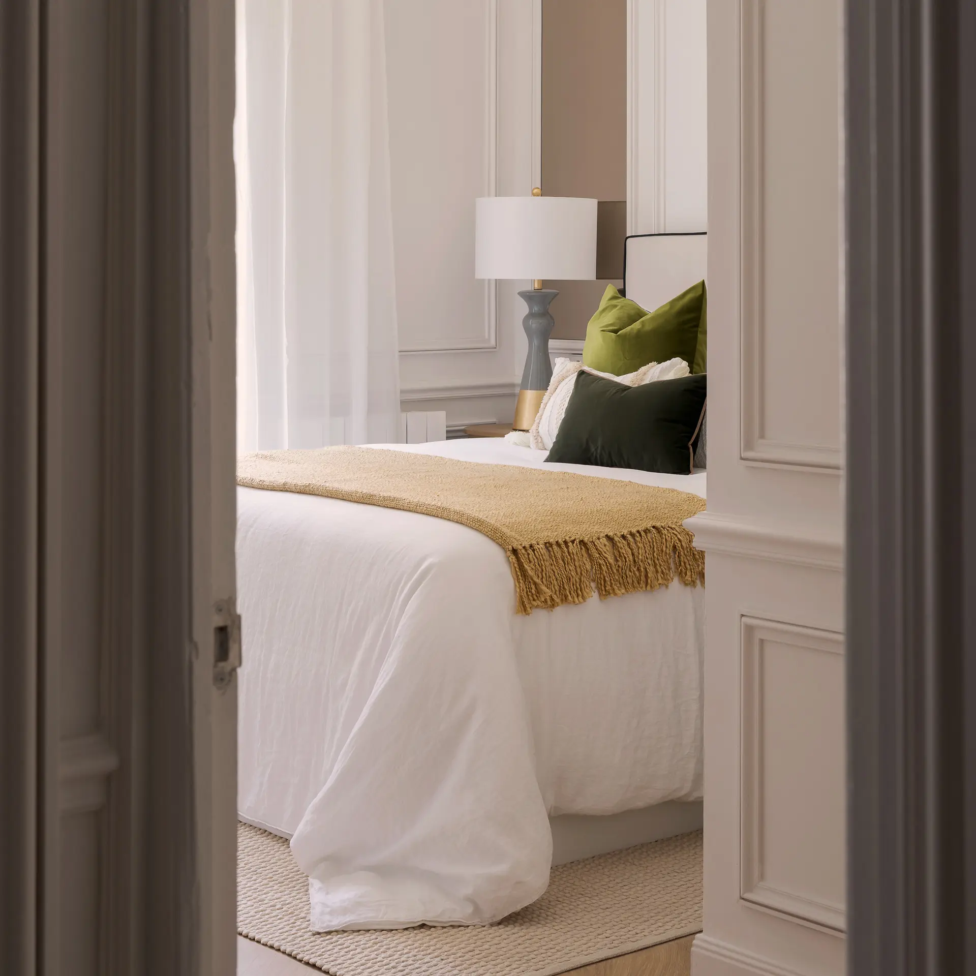 Fotografía de interiorismo de un dormitorio con luz cálida y detalles textiles, por Jon Alkain